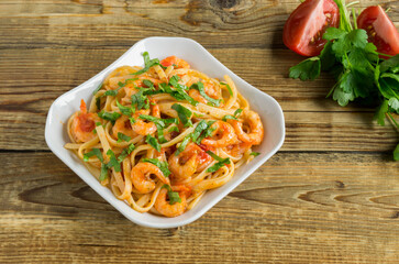 spaghetti with prawns in tomato sauce with herbs.