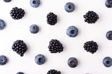 Fruit pattern from blueberries and blackberries isolated on white background. Top view. Flat lay. Full depth of field