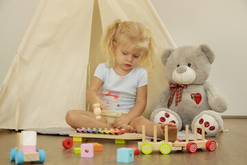Toddler girl playing xylophone at home.