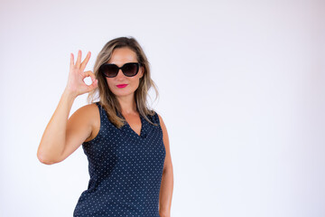 Beautiful woman in blue shirt and sunglasses gesturing