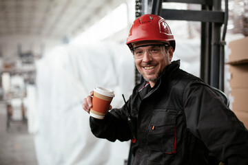Portrait of factory worker. Man drinking coffee in factory..