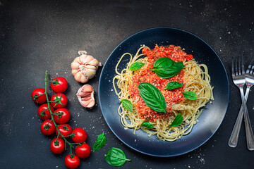 delicious appetizing classic spaghetti pasta, tomato sauce.with basil herbs parmesan cheese on dark background.Space for text. Overhead. Traditional Italian cuisine. Dark rustic wooden table.
