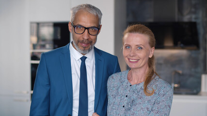 Close up portrait of affectionate middle-aged husband and wife in kitchen.
