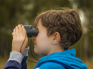 boy looking through binoculars