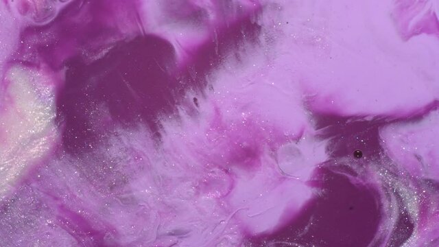 Purple, pink, pastel lilac, shiny white pearl colors mix. Paint movement macro. Ink flow. Glitter fluid motion. Moving flowing stream of liquid paint. Beautiful abstract background