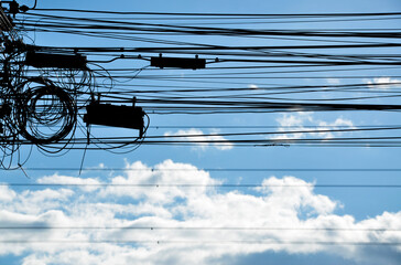 Electrical wire, communication cable on blue sky background