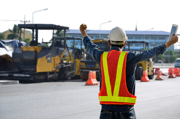 Obraz premium Successful male road construction engineers raised their hands with pleasure in the construction project that was being completed.