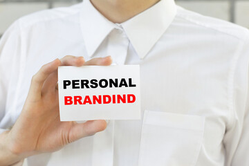 Businessman putting a card with text PERSONAL BRANDIND in the pocket