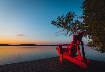 Muskoka chair on dock at sunset