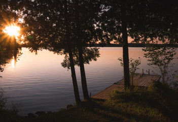 Dock and trees at sunset on lake