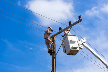electrician people work installation of high voltage on pole. Engineers working with high voltage...