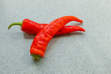 yellow, orange and red hot peppers on a gray table. Concept of the harvest season, bright autumn.
