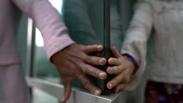 A black man and a white woman dance and hold hands on the street in the background of a business center. A beautiful interracial couple are located on a city street.