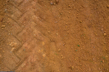 Close-up soil background and tire traces.