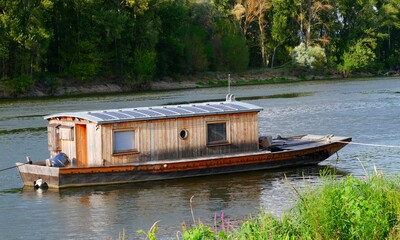 Holzboot in einem idyllischen Fluss, Hausboot