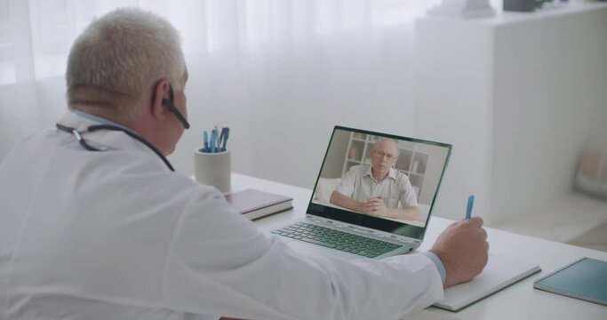 professional male therapist is listening complaints of patient by video call, consulting sick people online in office