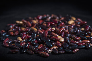Red, black and white beans close-up on a dark background. Vegetarian menu element.