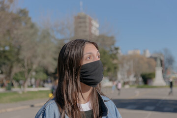 Mujer joven al sol con barbijo
