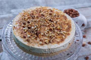 Cheese cake with hazelnuts on wood background