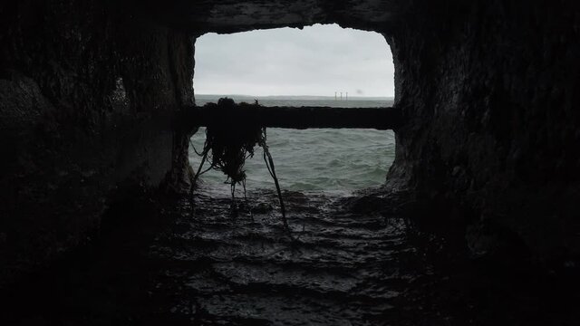 Still shot through a sea wall of a storm and rough waves. 4k, 19 seconds.
