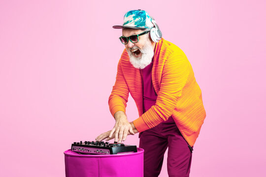 Party Drive. Portrait Of Senior Hipster Man In Fashionable Eyewear Isolated On Pink Studio Background. Tech And Joyful Elderly Lifestyle Concept. Trendy Colors, Forever Youth. Copyspace For Your Ad.