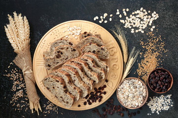High fibre health food with raisin rye bread loaf, bowls of raisins and muesli, with barley flakes, flax seed and sheaths of grain. High in antioxidants, omega 3, vitamins and protein with low gi.  
