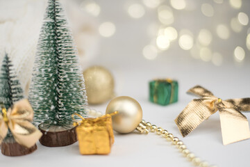 Two little Christmas trees decorated and gifts for the new year on the bokeh background, new year composition