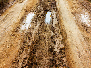 Traces of off-road tires. Cracked earth on country road with traces of tires, cars, cracks and...