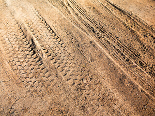 Traces of off-road tires. Cracked earth on country road with traces of tires, cars, cracks and dirt. To use as background.