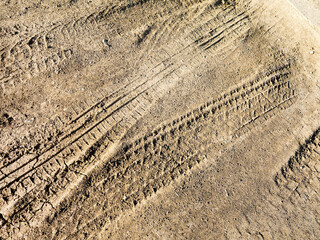 Traces of off-road tires. Cracked earth on country road with traces of tires, cars, cracks and...