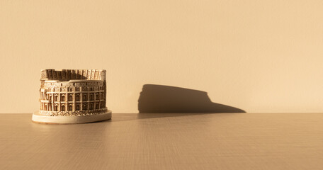 coliseum on a wooden table with his shadow