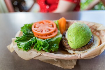 Large appetizing Hawaiian burger with avocado on a beef patty