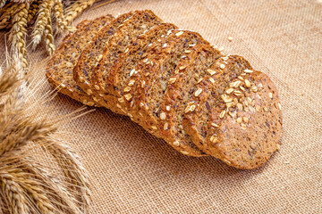 Loaf bread. Rye bakery with crusty loaves and crumbs. Fresh loaf of rustic traditional bread with wheat grain ear or spike plant on natural cotton background. Bio ingredients, very healthy seeds.