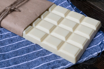 White chocolate tablet on rustic background