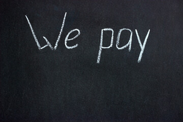 The inscription on the chalkboard "We pay". A common phrase in business and finance