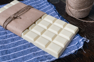 White chocolate tablet on rustic background