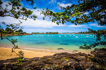 Fototapeta na wymiar Small bay with boats at the emerald coast in Brittany, France