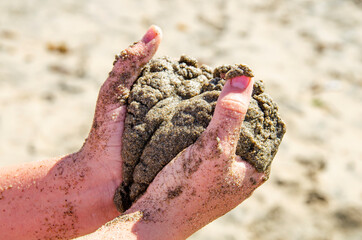 Child holding sand in his hands