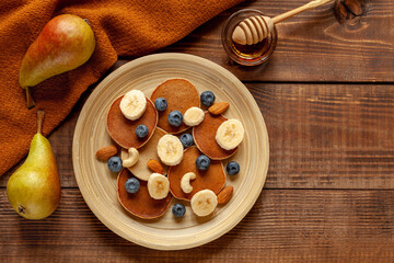 American breakfast with pancakes and berries on wood background, top view