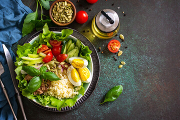 Healthy food. Tuna salad with egg, lettuce, quinoa, vegetables and pumpkin seeds. Top view flat lay background. Copy space.