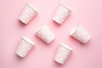 Polka dot disposable paper cups on pink background