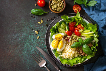 Healthy food. Tuna salad with egg, lettuce, quinoa, vegetables and pumpkin seeds. Copy space.