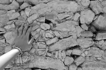 mano sobre pared de piedra