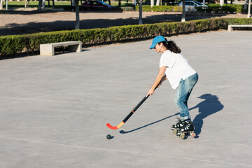 Girl playing roller hockey in the park.