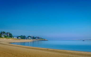Fototapeta na wymiar Tranquil Coastline Seascape with Clear Blue Sky over Curving Sandy Beach on Cape Cod
