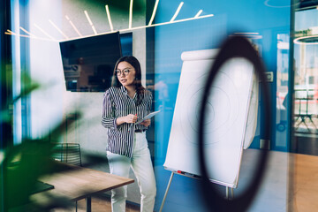 Young woman standing in front of flip chart in office
