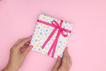 One gift in woman hands on pink theme 