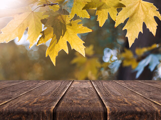 Naklejka na ściany i meble Wooden desk on autumn blur abstract natural background