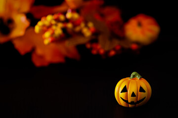 ハロウィンのイメージ素材　黒地にカボチャ　秋の葉と木の実などの背景ぼかし