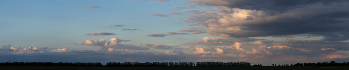 Landscape at sunset. Tragic gloomy sky. The village in the Budjak steppe. The terrain in southern Europe. Panorama.